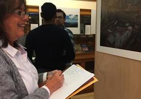 Professor Claudia Valeggia views each of the photographs in the exhibit.